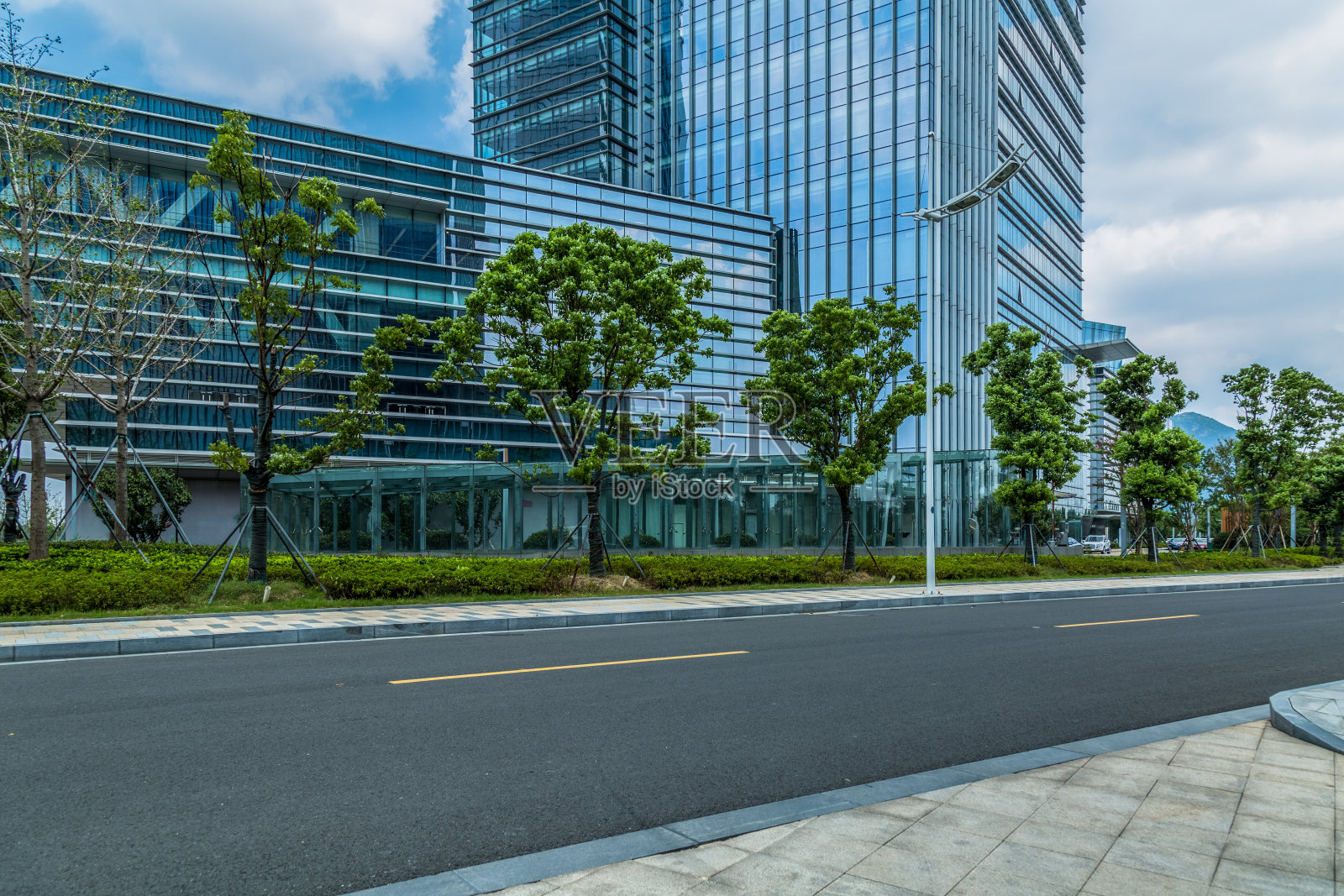 玻璃办公楼附近的沥青路空荡荡照片摄影图片
