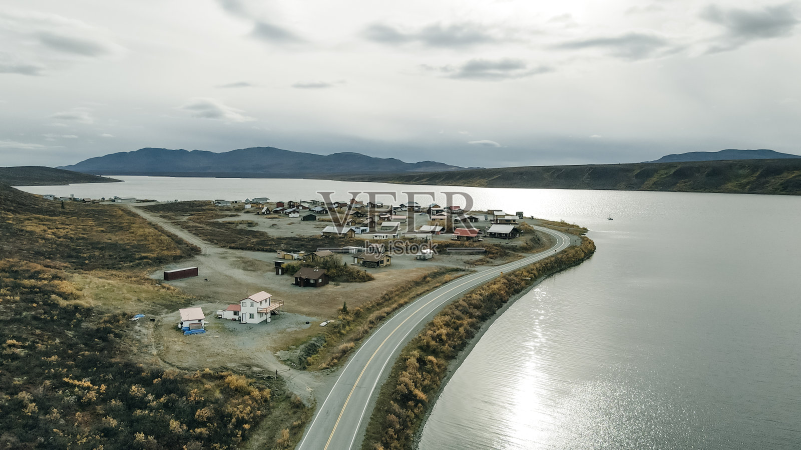 在阿拉斯加的基奈半岛，宁静的湖面和雄伟的山峰上，充满戏剧性和忧郁的天空。照片摄影图片