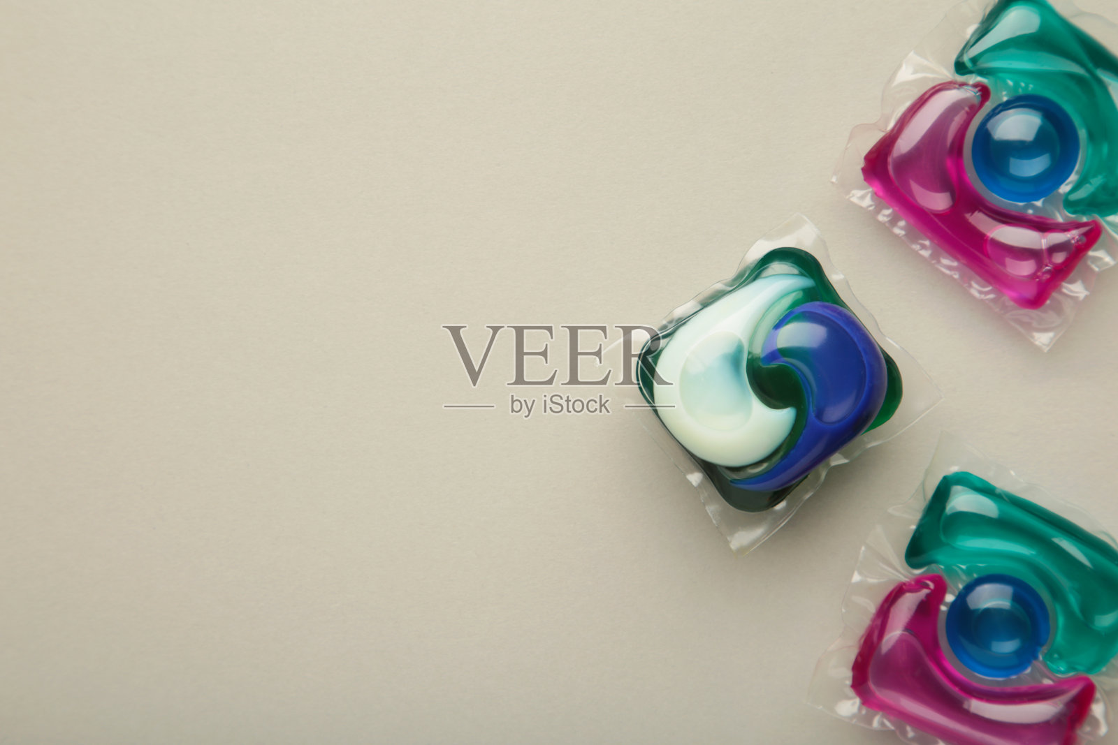 洗衣胶囊洗衣粉荚用于在灰色背景上洗衣服。照片摄影图片