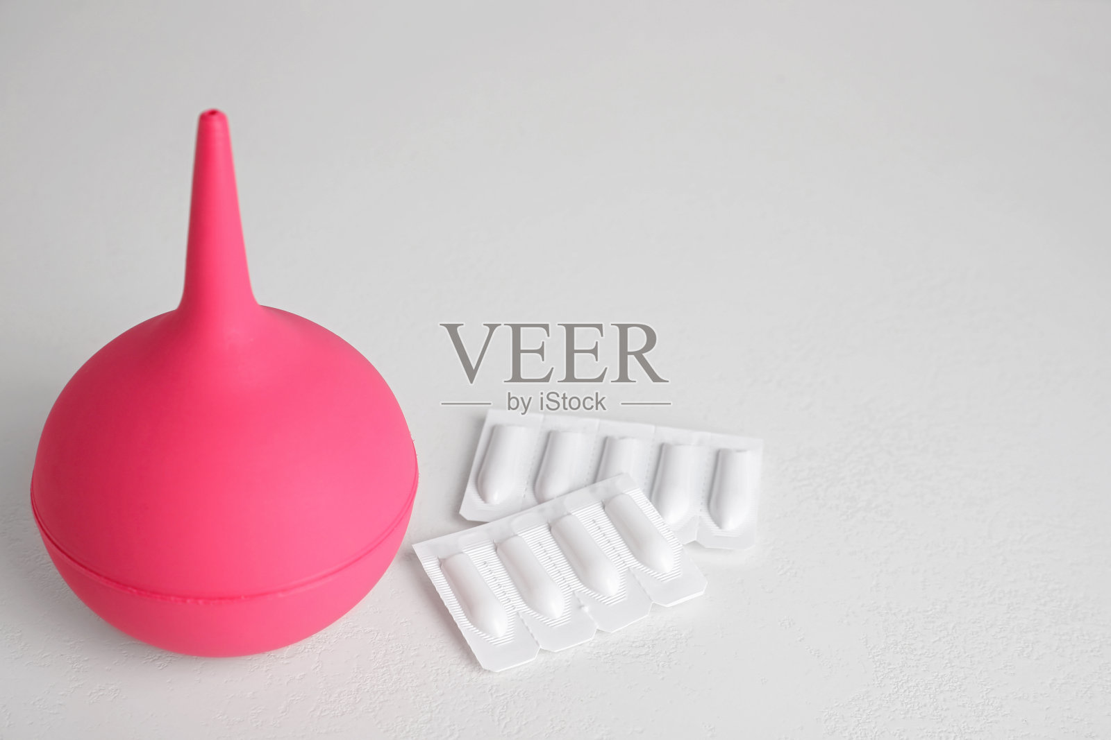 灌肠剂和栓剂放在白色的桌子上。医疗照片摄影图片