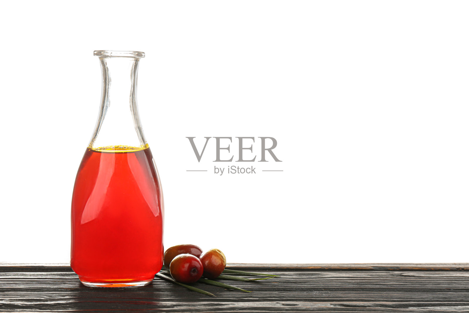 棕榈油在玻璃瓶子和水果在白色背景木制桌子上照片摄影图片