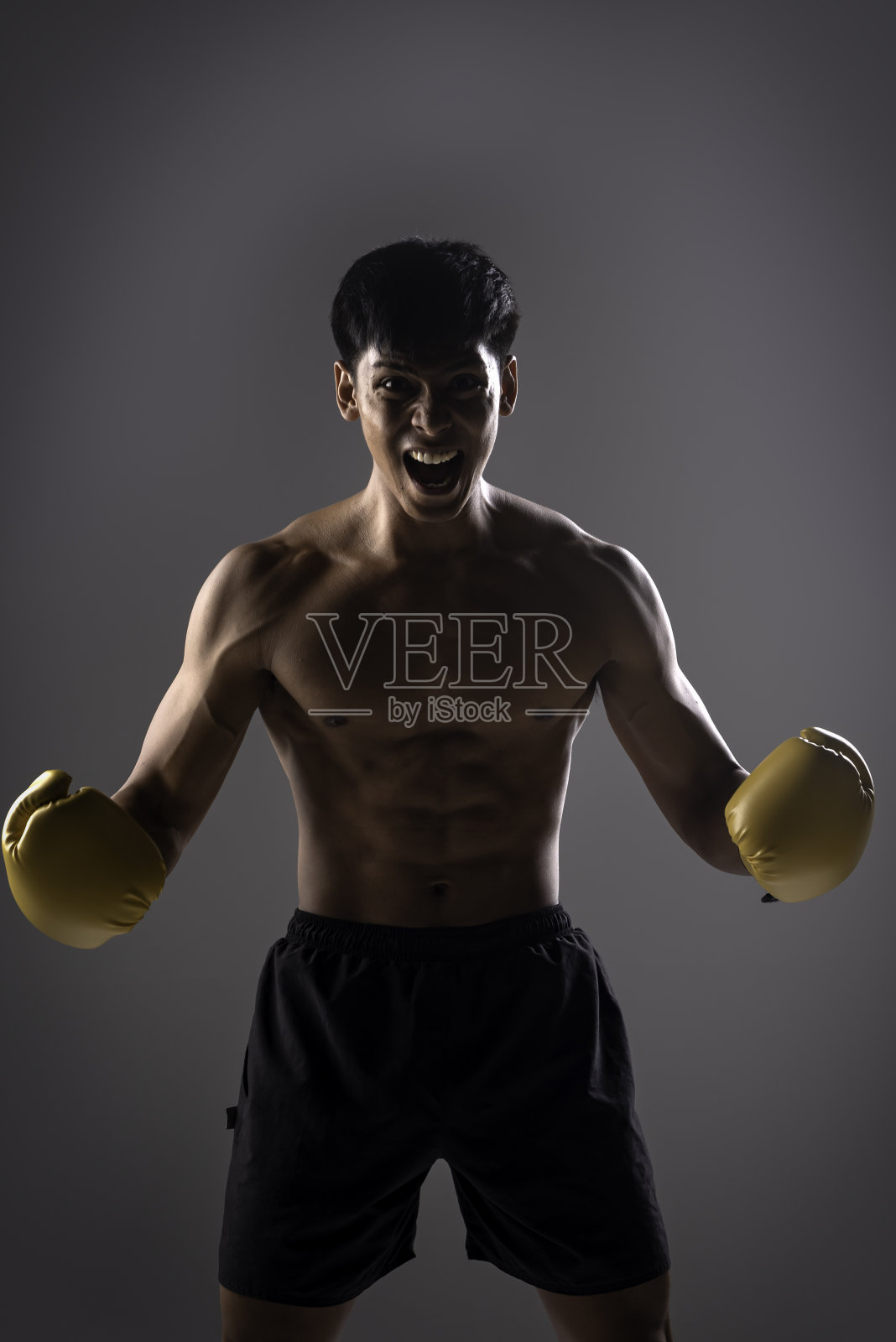 强壮的男子在拳击风格，包在手上的布的拳击练习。照片摄影图片