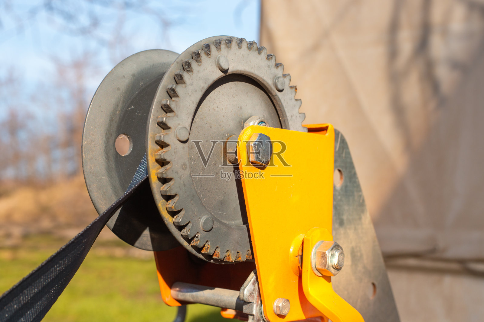 手动绞车机构关闭。带张紧皮带的牵引绞车的铁齿轮。特种设备的装卸照片摄影图片