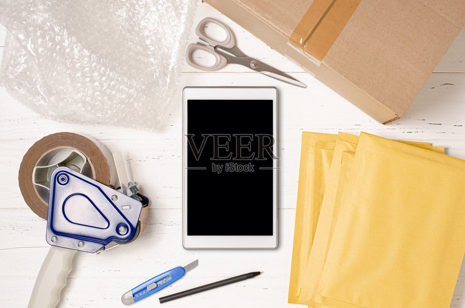 纸箱、智能手机、气泡膜和包装工具：网店包裹包装概念照片摄影图片