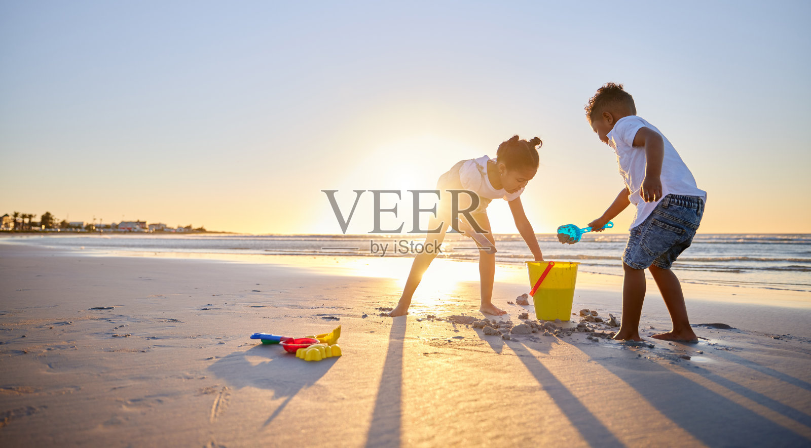 一个年轻的兄弟姐妹在海滩上亲密无间的照片照片摄影图片