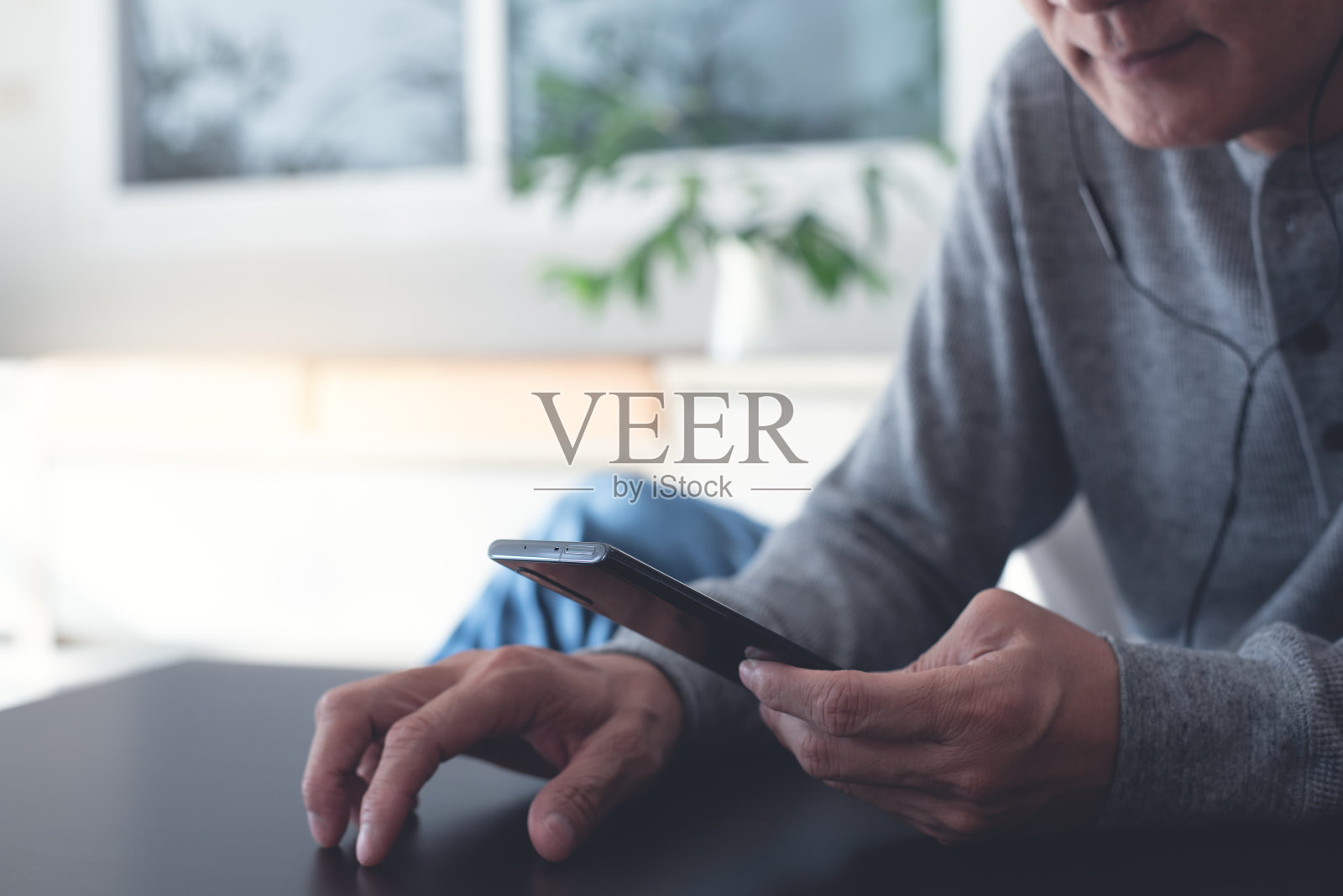 戴着耳机在家听播客的男人照片摄影图片