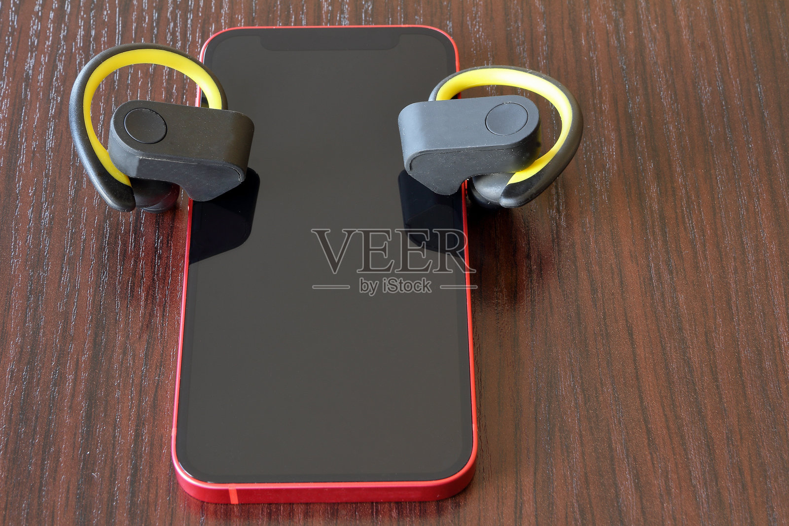 红色手机和黄色无线耳机照片摄影图片