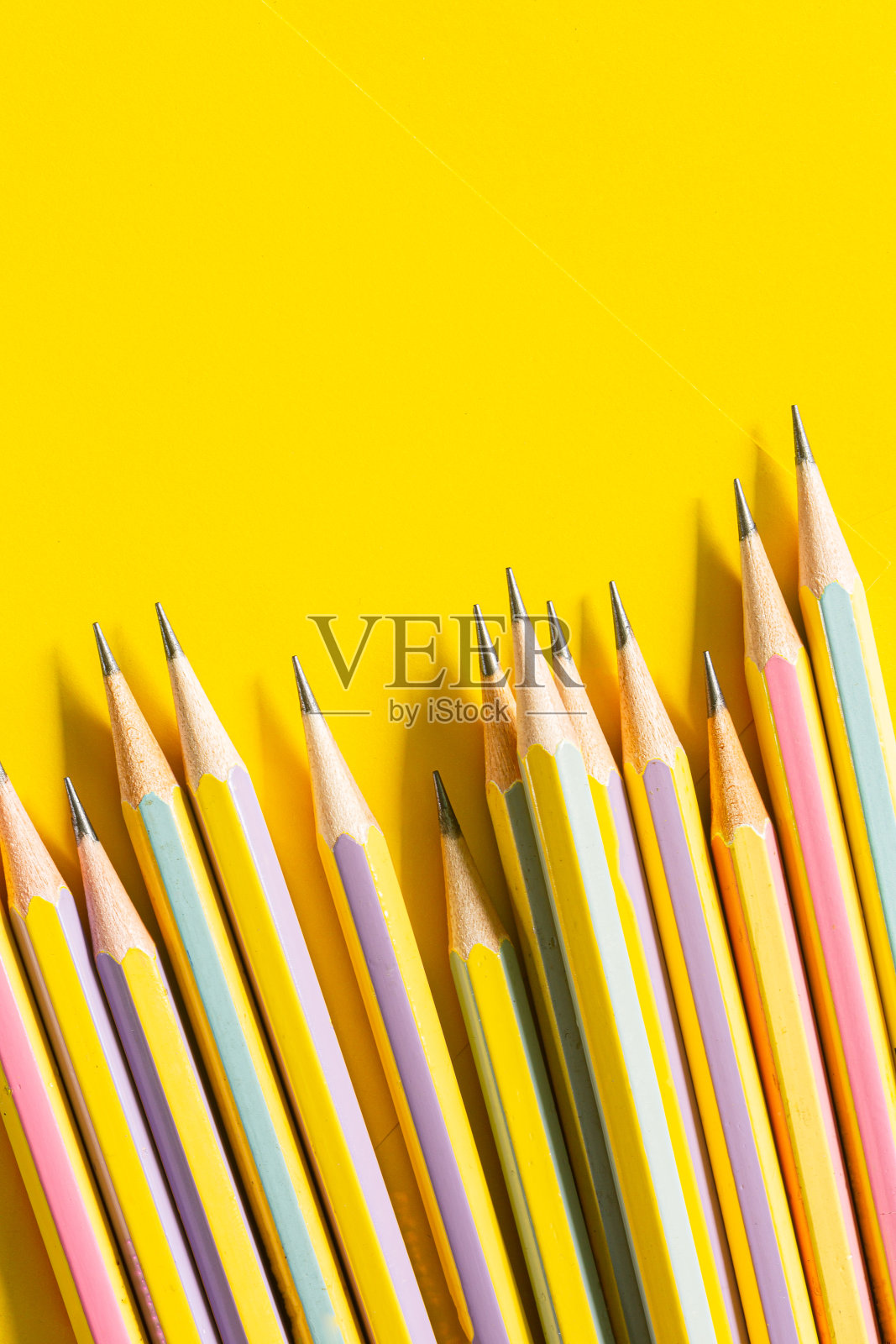 几支铅笔在黄色的纸上，回到学校的边界上的彩色铅笔孤立在黄色的背景上照片摄影图片