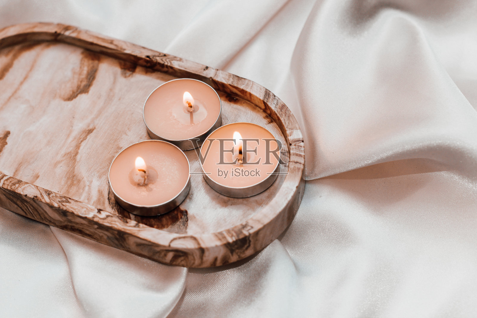 石膏大理石装饰站与蜡烛在背景的丝绸站照片摄影图片