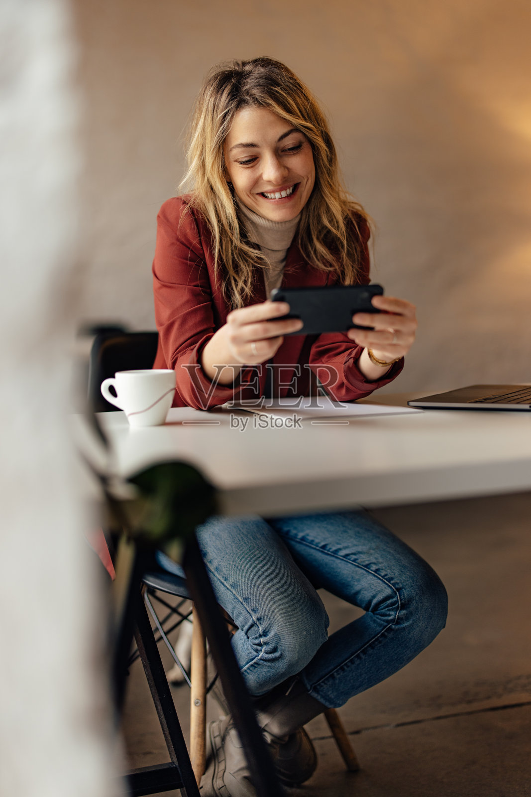 年轻女子，坐在办公室里，打电话，上网。照片摄影图片