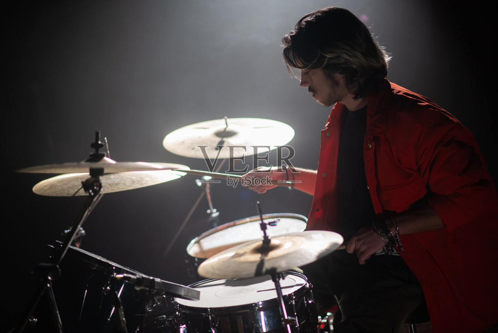 一个年轻人在音乐会上聚精会神地打鼓照片摄影图片