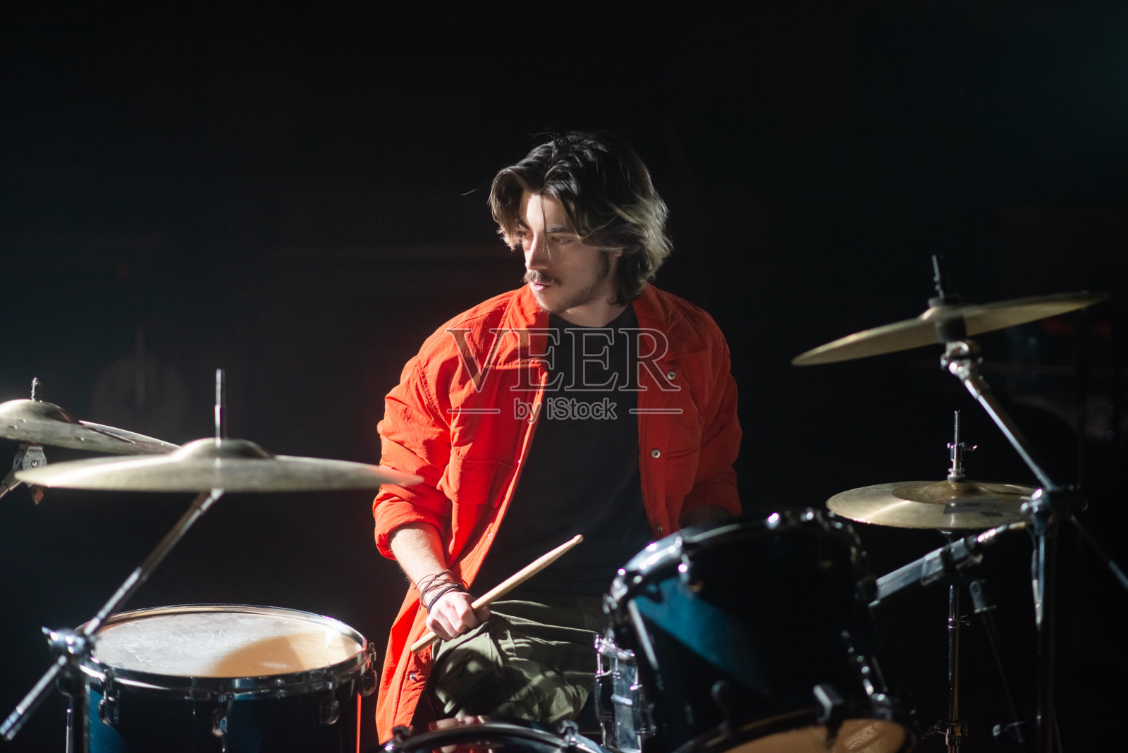 年轻的白人鼓手在演播室排练照片摄影图片