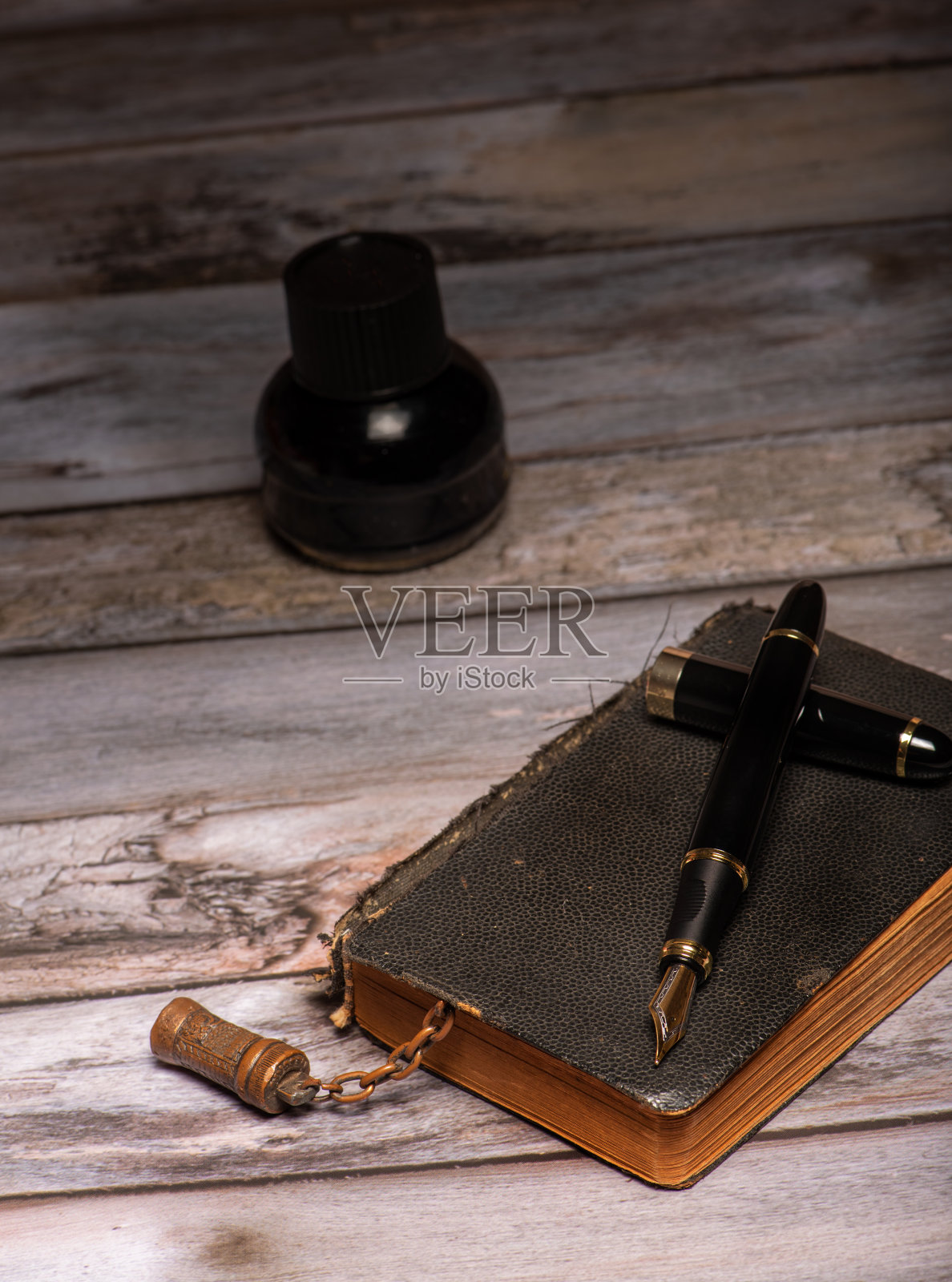 钢笔，漂亮的钢笔在一个环境中与旧钟，旧书，墨水等，选择性的聚焦。照片摄影图片