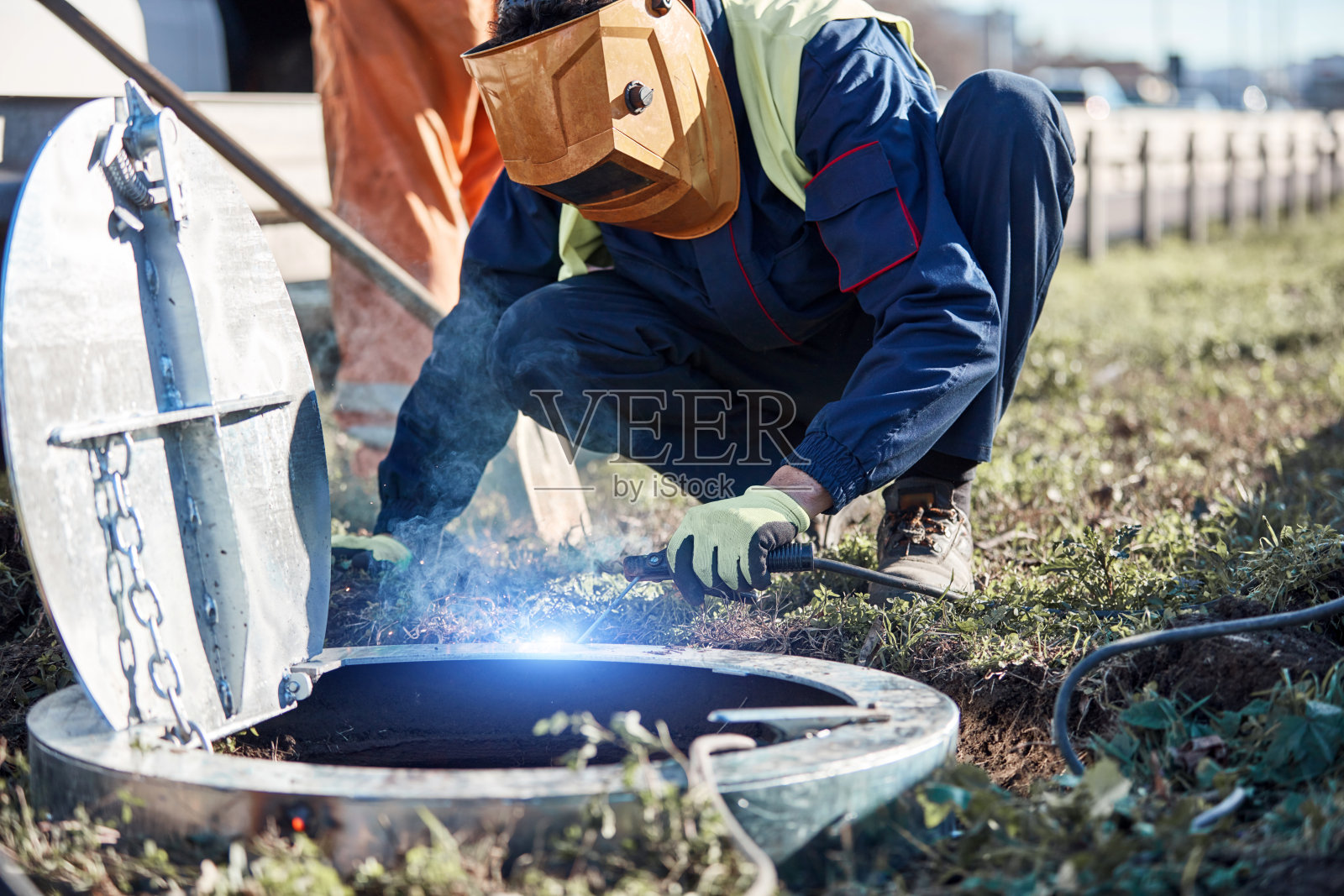 电焊工，下水道井盖上的杂工。照片摄影图片