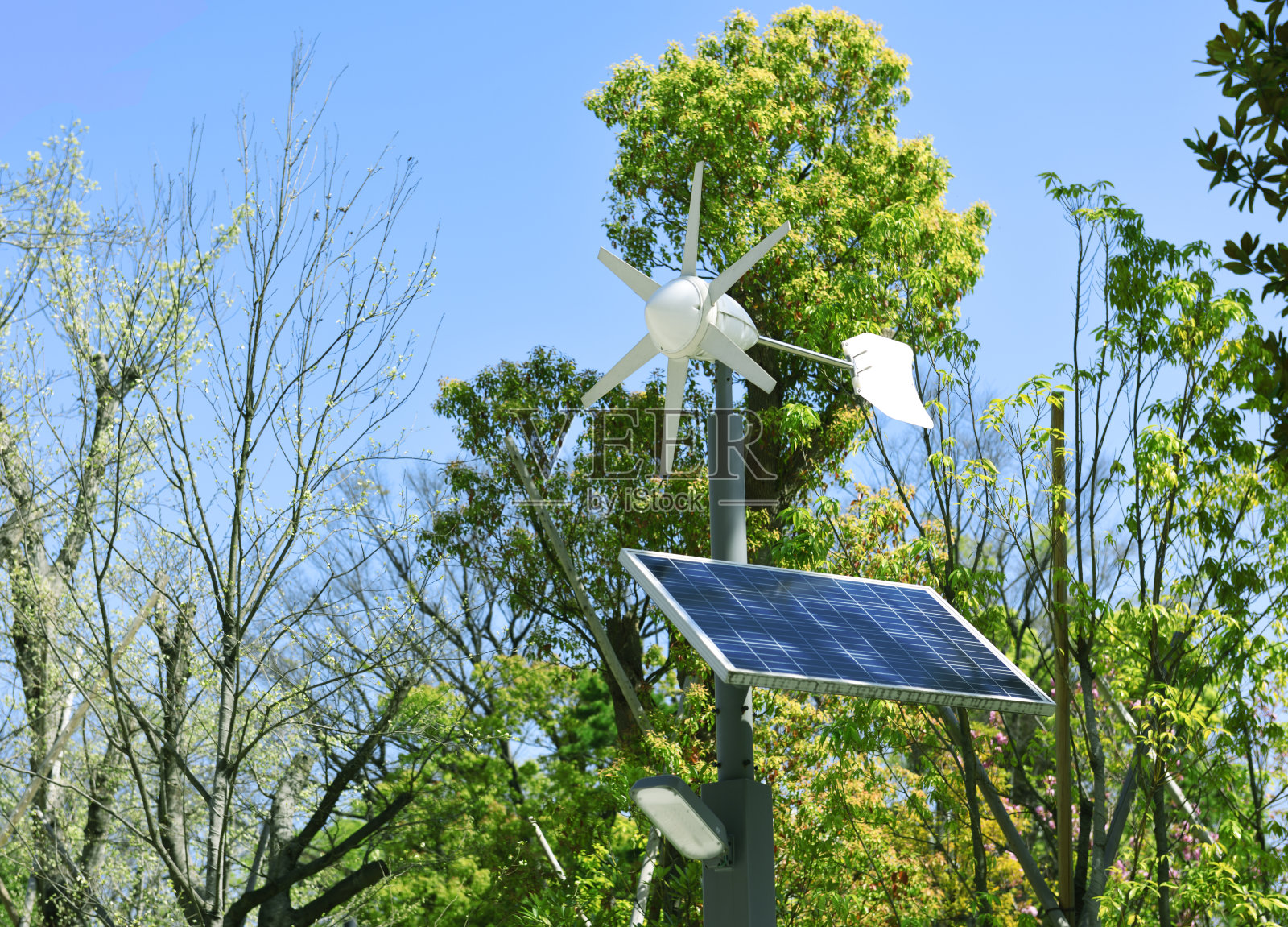 在晴朗的天空下使用太阳能和风力发电机照片摄影图片