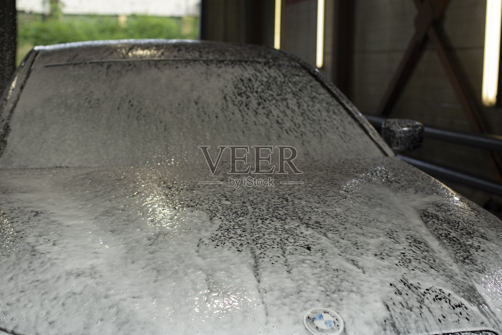 洗车房的车。泡沫车。白色的肥皂溶液。清洁的交通工具。照片摄影图片