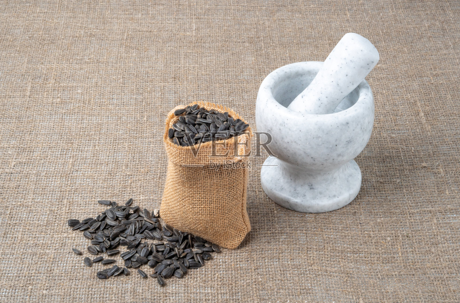 葵花籽油，葵花籽在袋子的背景上。照片摄影图片