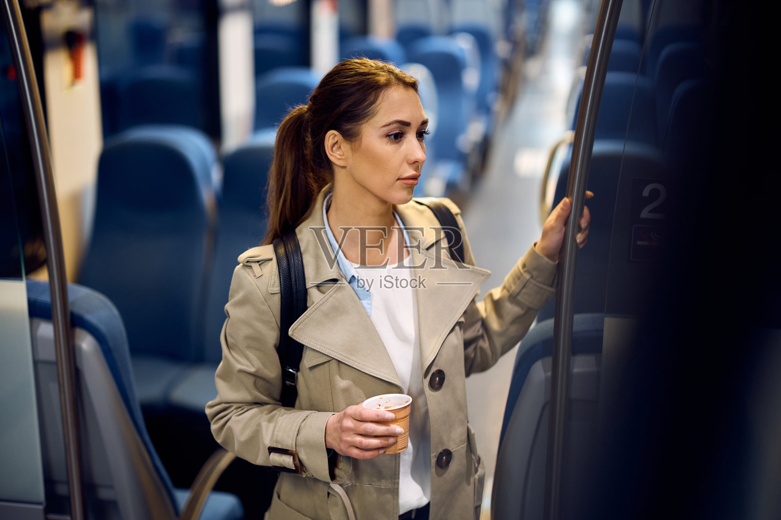 年轻沉思的女人带着外卖咖啡乘火车上下班。照片摄影图片