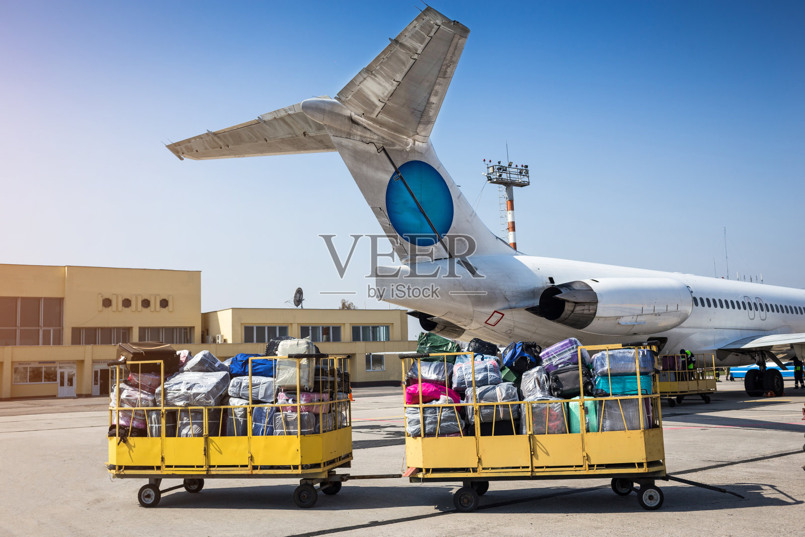 把行李装上飞机。行李运输用拖车将行李运送到飞机上照片摄影图片
