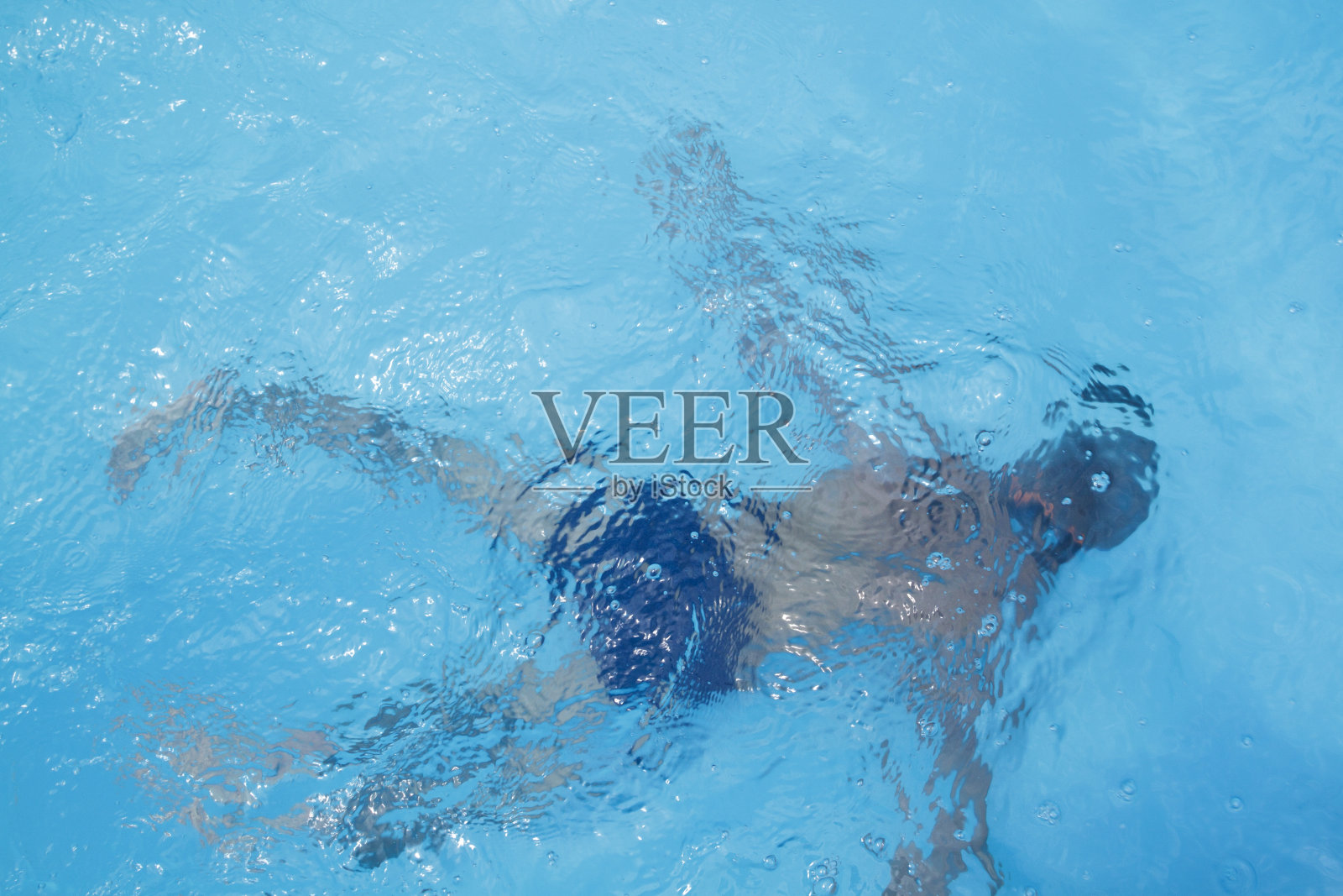 小孩子在游泳池里跳水照片摄影图片