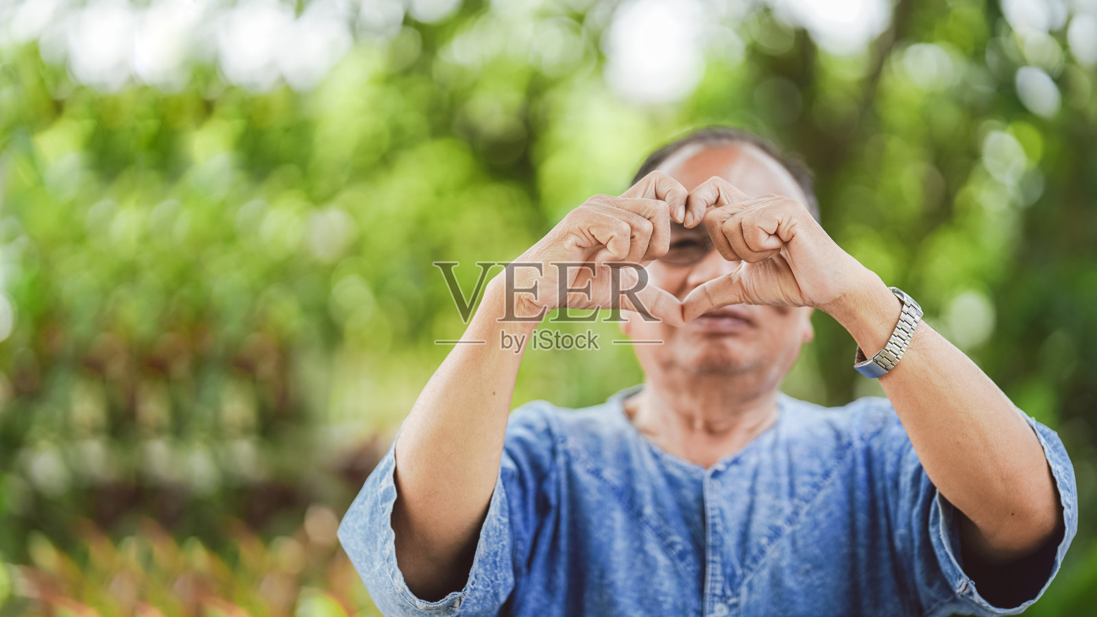 泰国老人将他们的手做成一个心形的象征。副本的空间。照片摄影图片