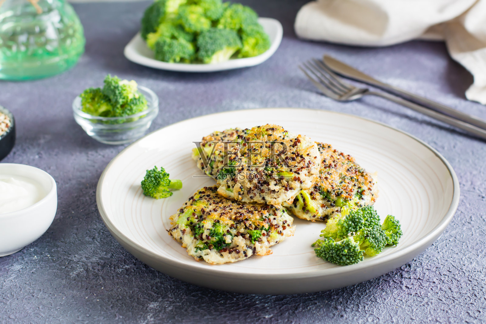 煎奎奴亚藜和西兰花混合煎饼放在盘子里。照片摄影图片