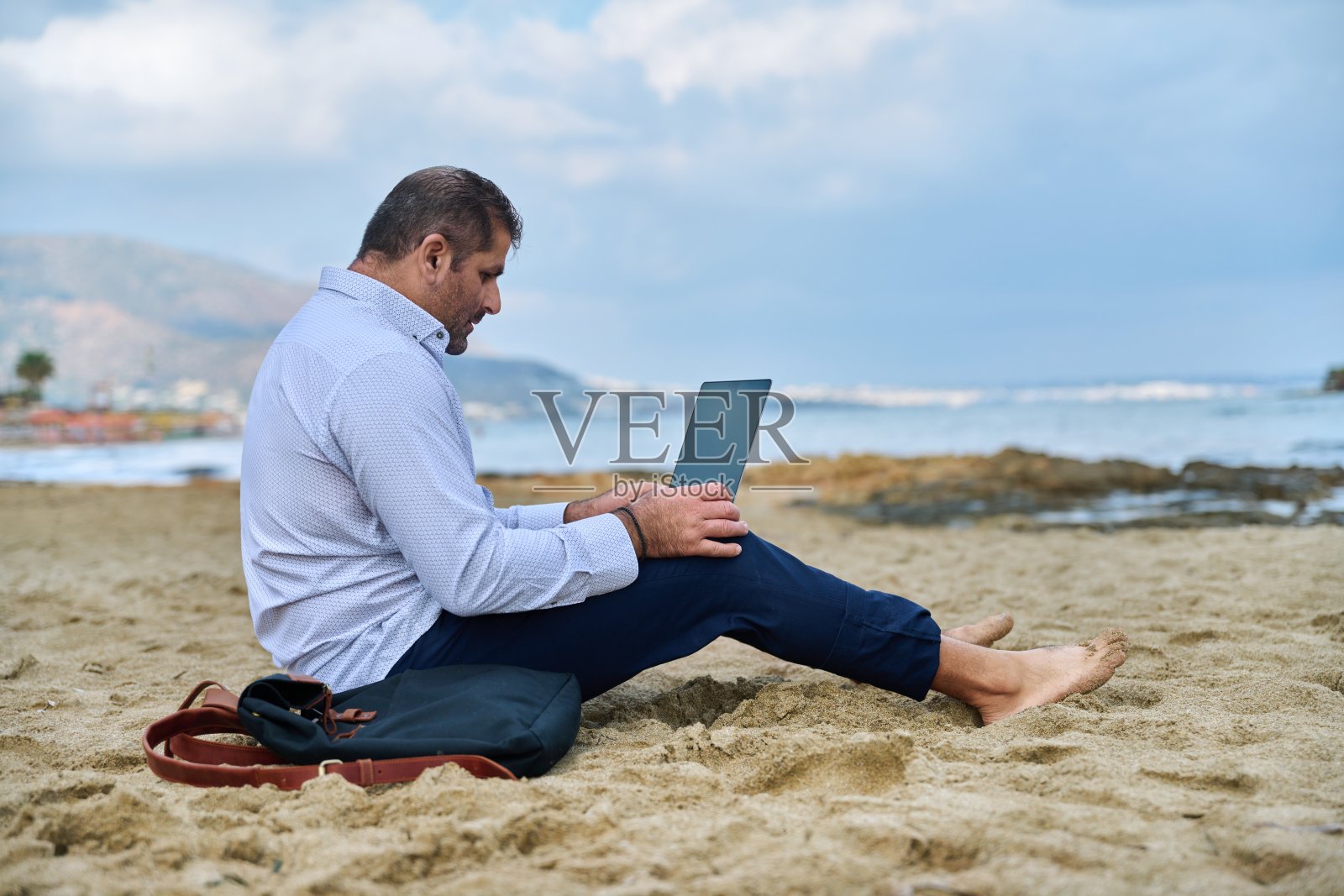 严肃自信的成熟男人带着笔记本电脑在户外照片摄影图片