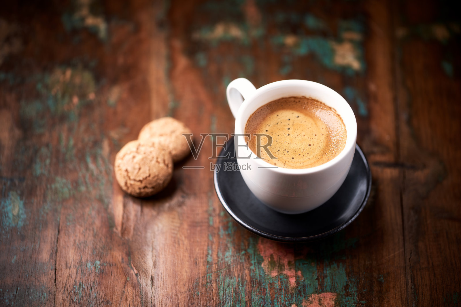 在质朴的木质背景上，一杯加意大利杏仁饼干的咖啡。关闭了。照片摄影图片