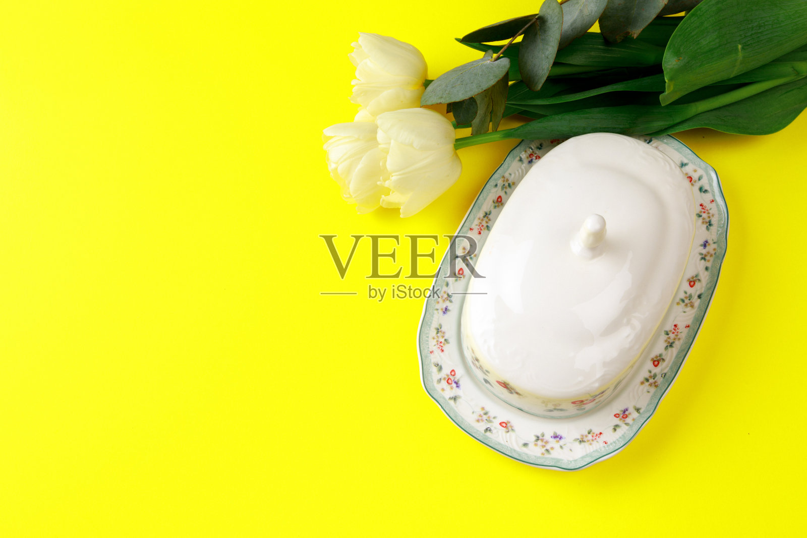 黄油盘和白色郁金香的颜色背景照片摄影图片