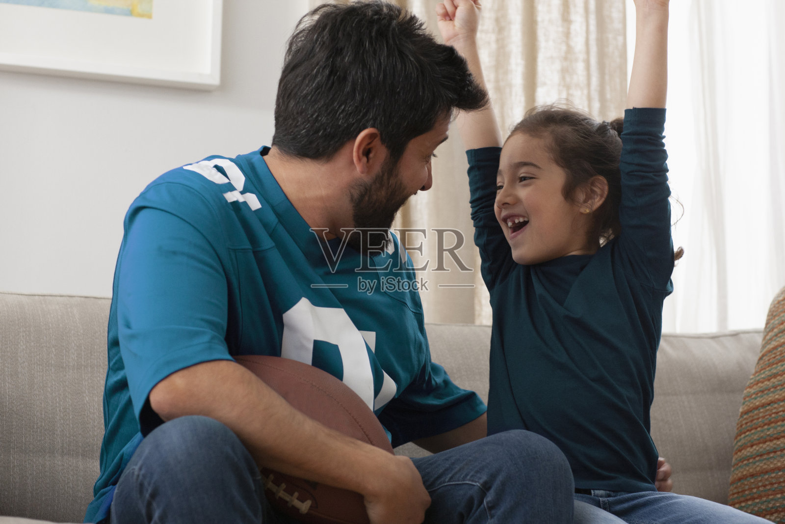 父亲和女儿一起看体育比赛照片摄影图片