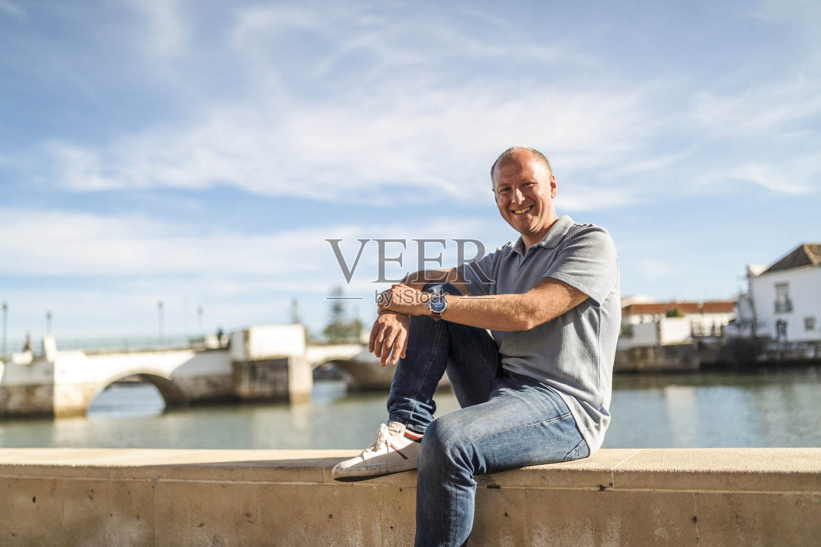 在葡萄牙阿尔加维的塔维拉，一名微笑的男子在河边放松的肖像照片摄影图片