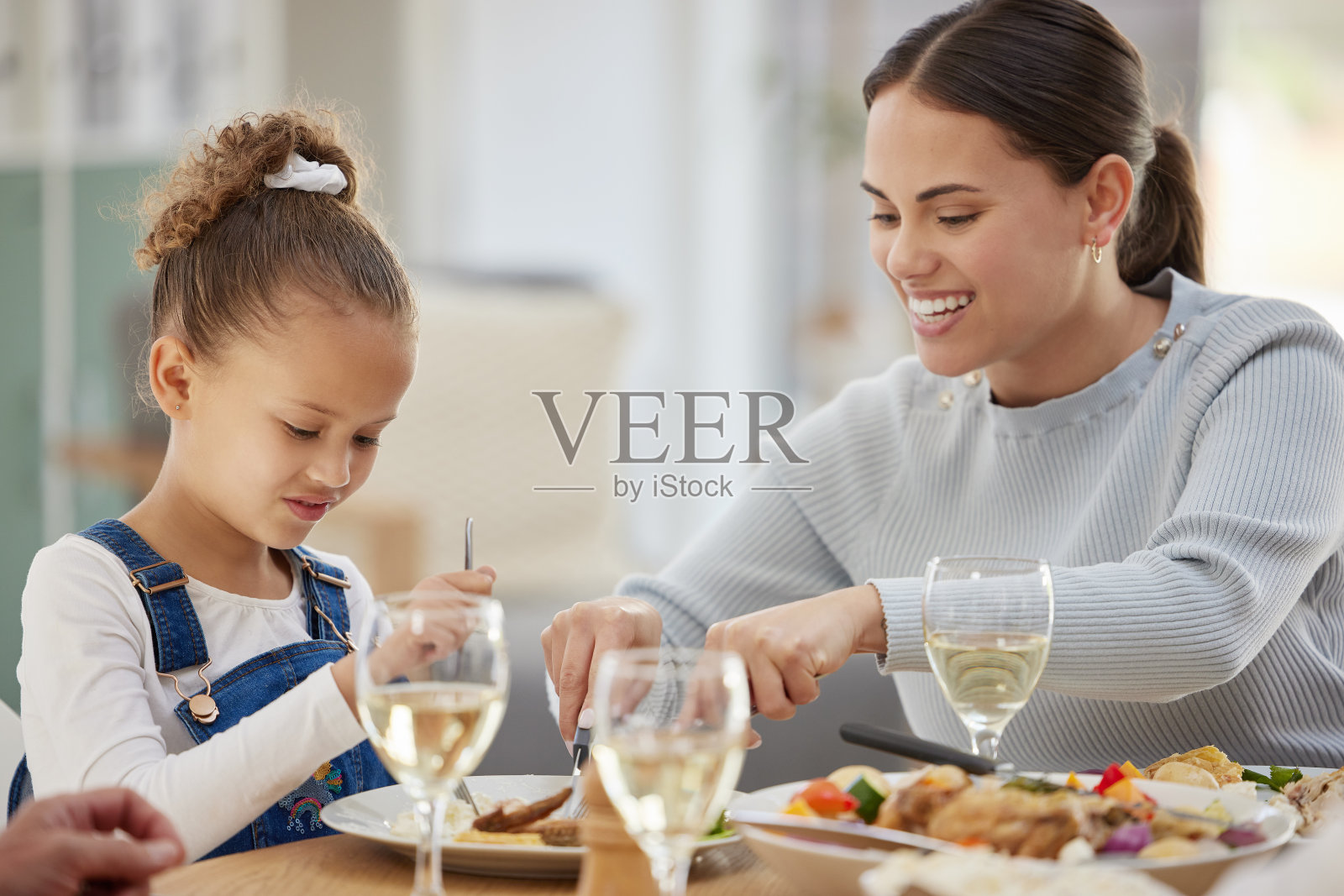 一个母亲为她的小女孩切食物的镜头照片摄影图片