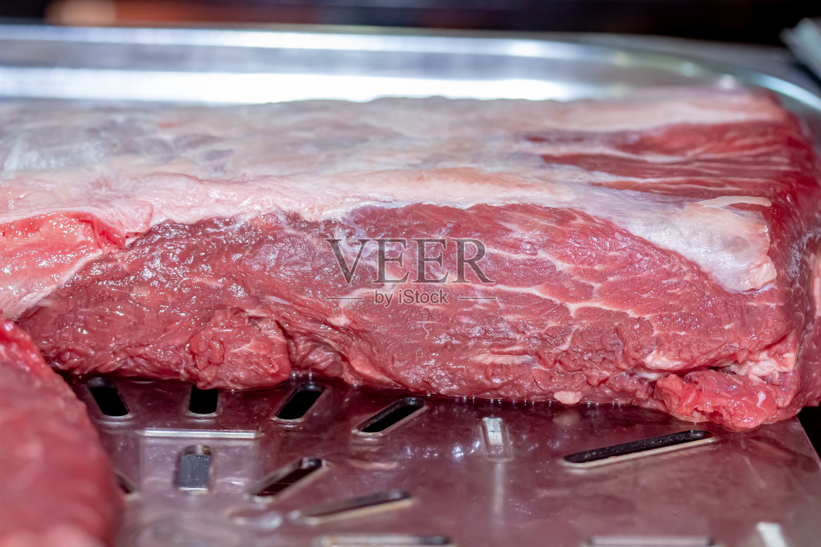 餐馆里有一块切得很好的大理石纹牛排，正等着烹饪照片摄影图片