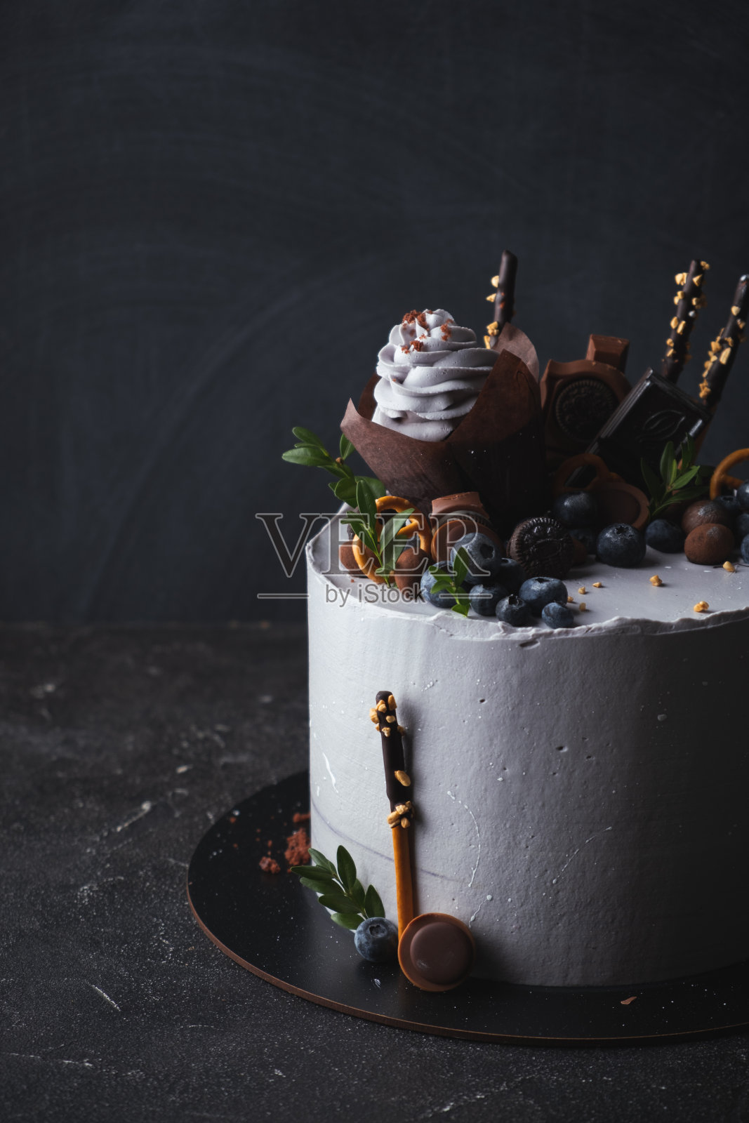 生日蛋糕，紫罗兰奶油芝士糖霜装饰纸杯蛋糕，蓝莓和巧克力饼干照片摄影图片