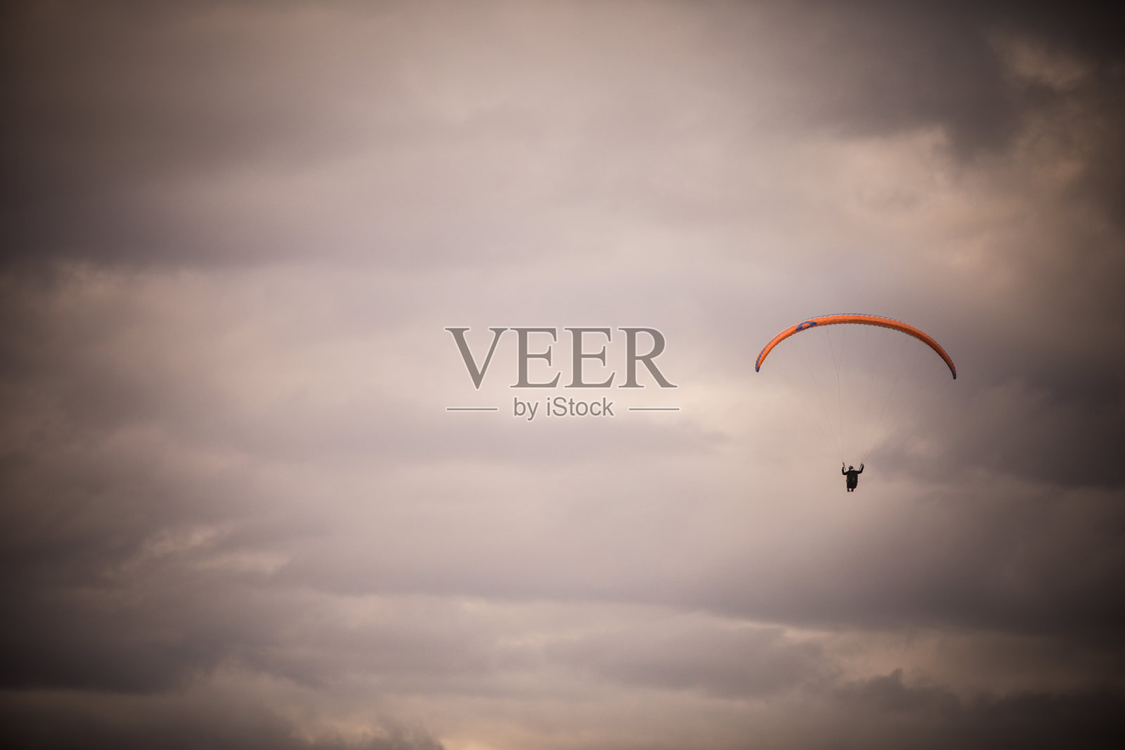 在多云的天空中独自飞翔的滑翔伞照片摄影图片