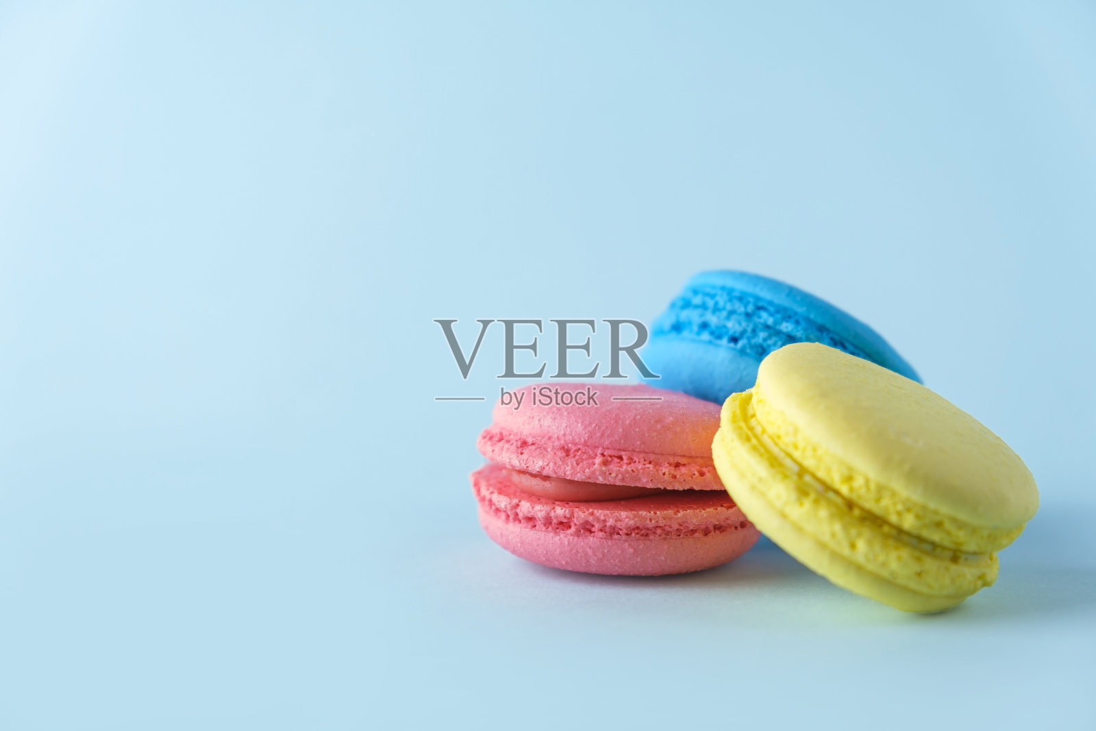 蓝色背景的法式马卡龙饼干(马卡龙饼干)。甜点，素食甜点照片摄影图片