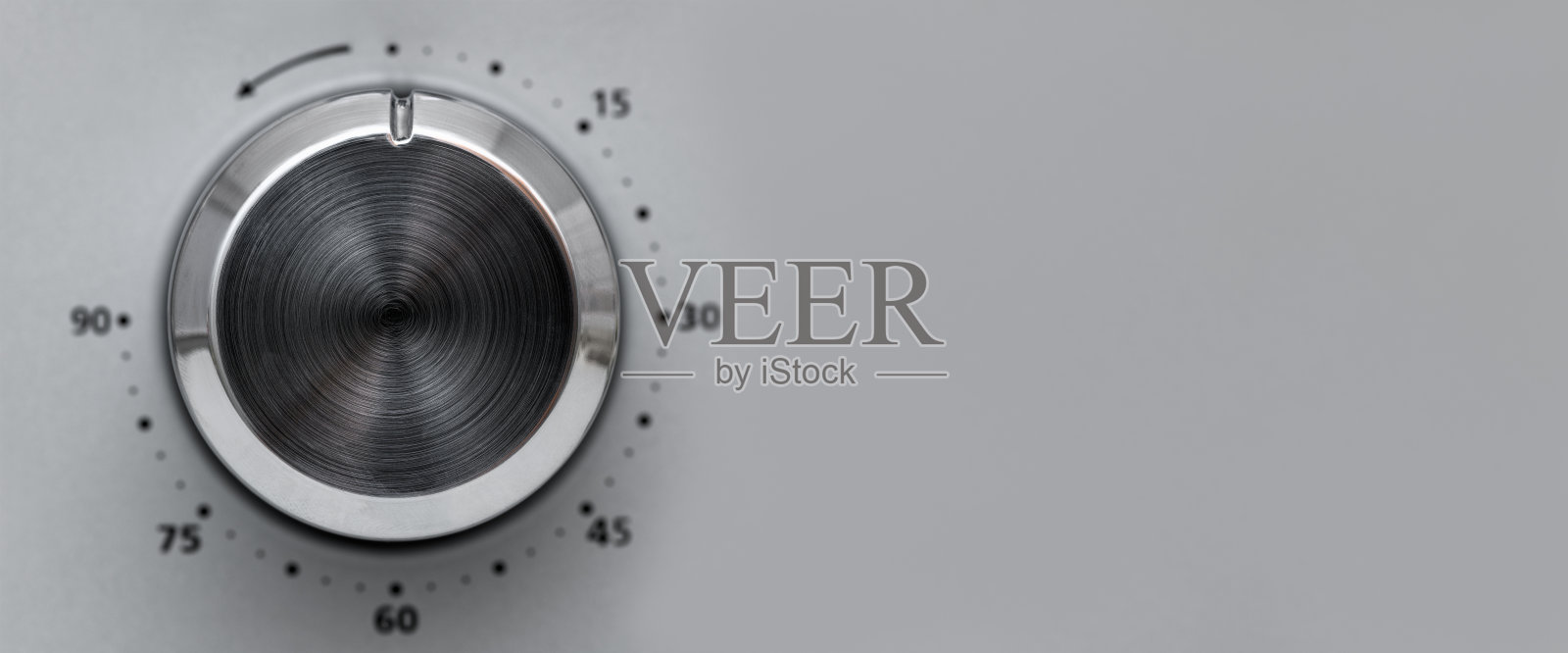 圆形按钮，用于控制微波炉的温度。按钮在灰色背景上加热食物。横幅照片摄影图片