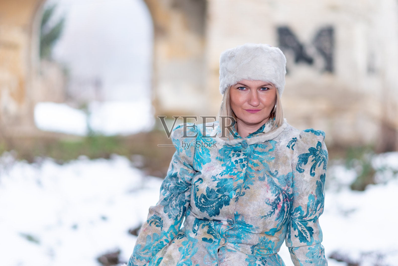 冬天的女王在一座废弃的城堡里。一个穿着冬装的漂亮女人照片摄影图片