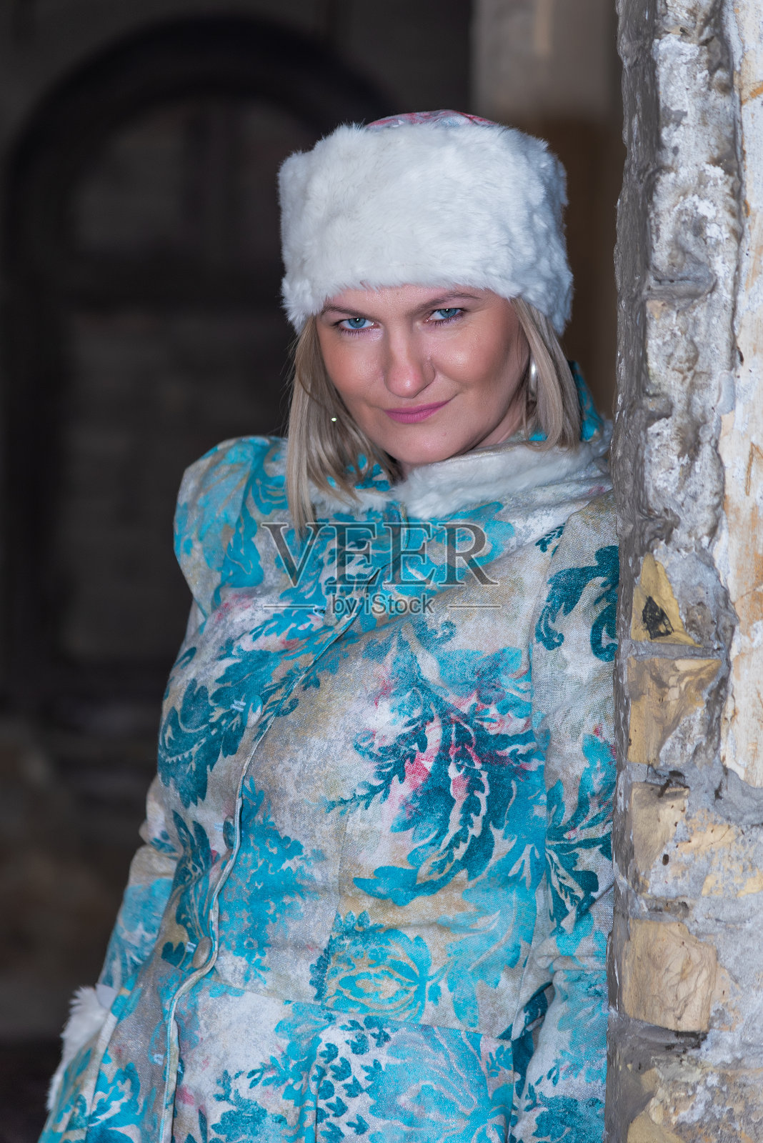 冬天的女王在一座废弃的城堡里。一个穿着冬装的漂亮女人照片摄影图片