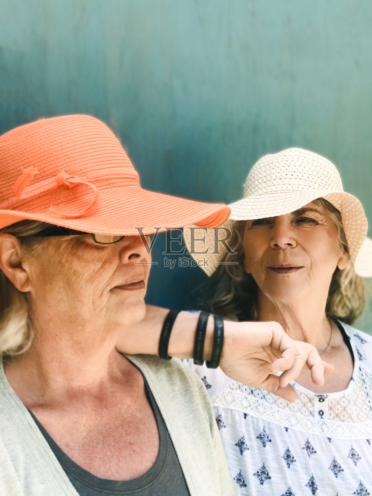 两个戴着大草帽的大四姐妹在户外亲密无间的肖像。照片摄影图片