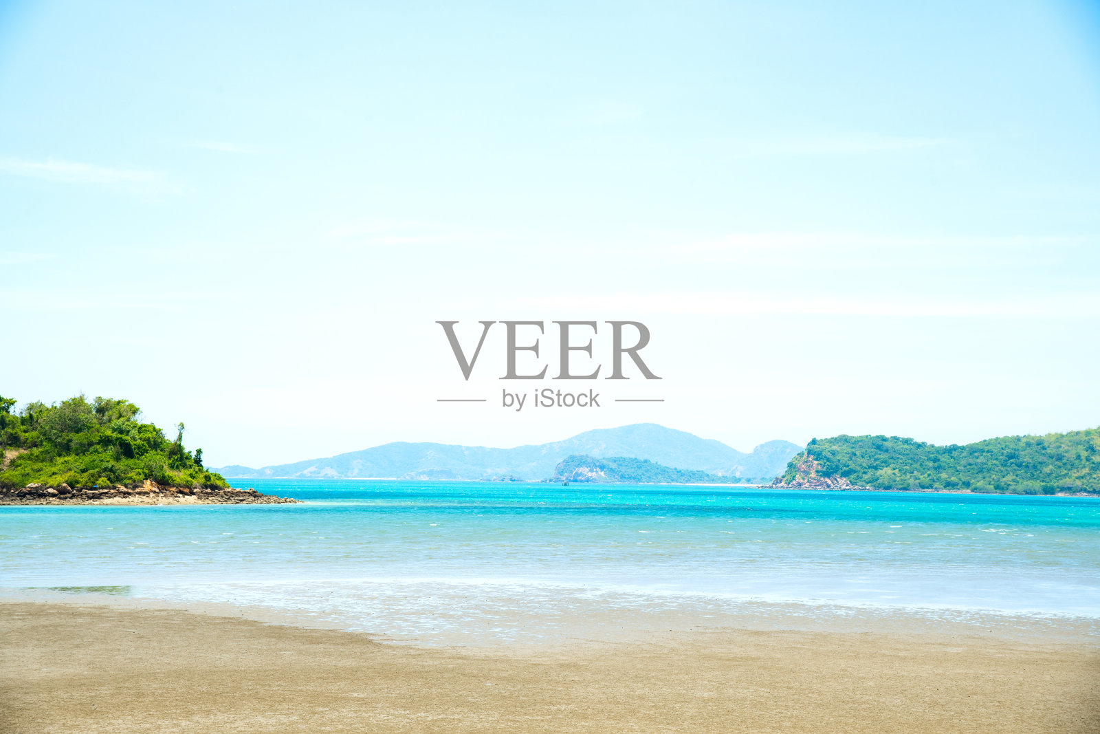 泰国的风景海滩背景。淡蓝色的天空，绿色的山背景，海浪和沙滩，柔和的风格。概念暑假和假日旅游。照片摄影图片