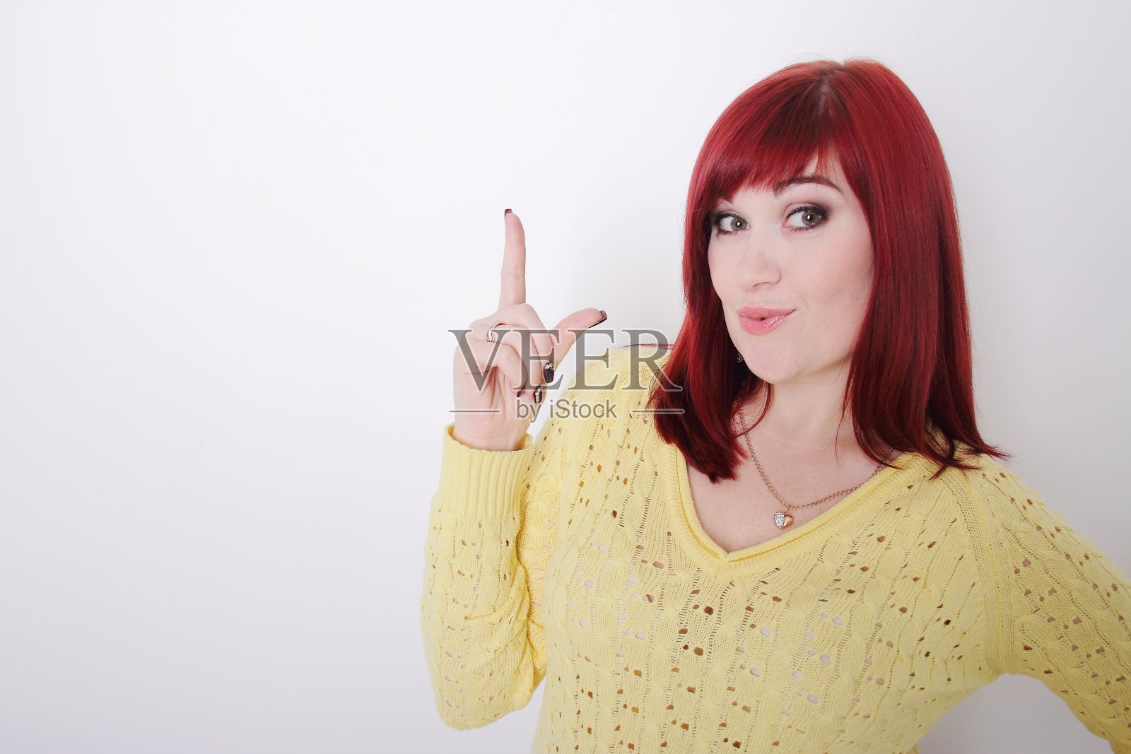 年轻的成年女子指着，手指向上，复制空间照片摄影图片