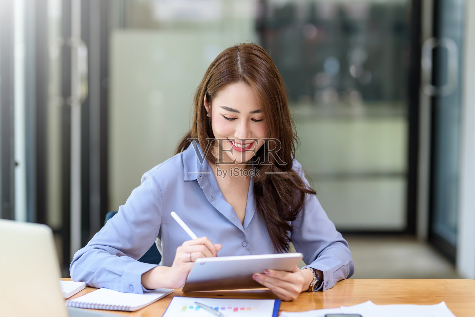 肖像微笑美丽的亚洲女商人坐享受的想法与平板电脑和笔记本电脑在办公室。照片摄影图片