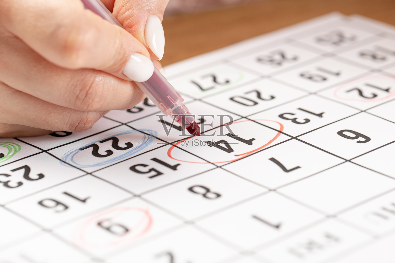 女性手用红笔在日历上圈出日期、截止日期的概念照片摄影图片
