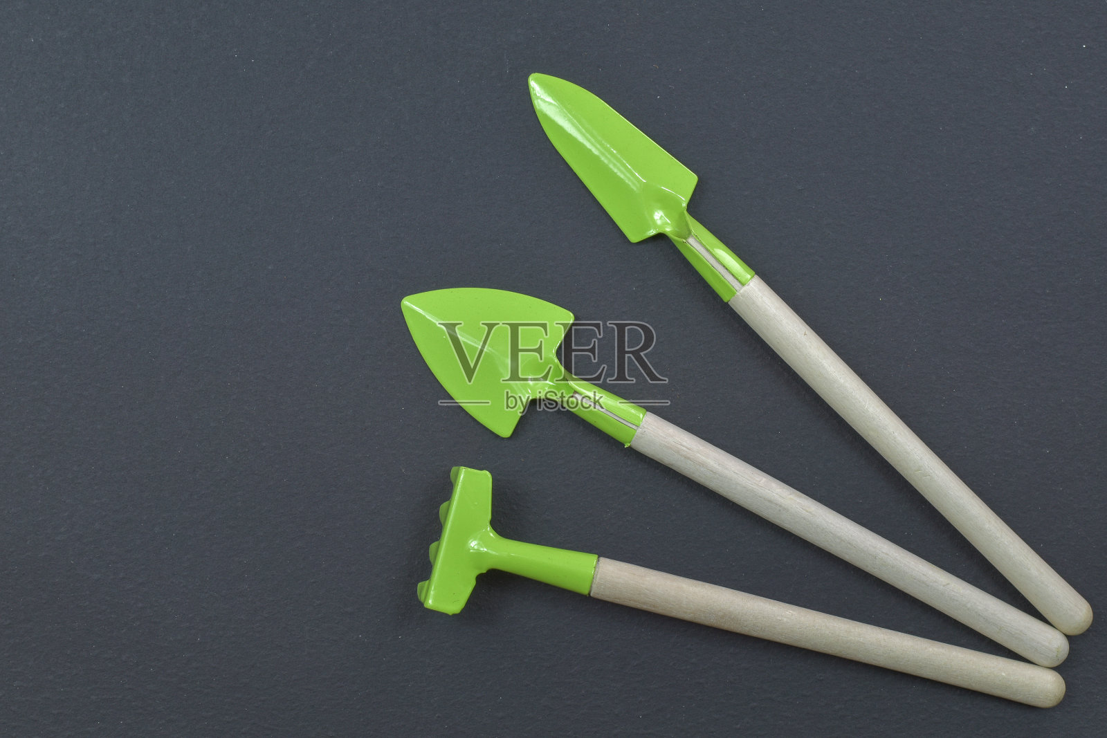 黑色背景上的小园艺工具。空间的文本。俯视图照片摄影图片