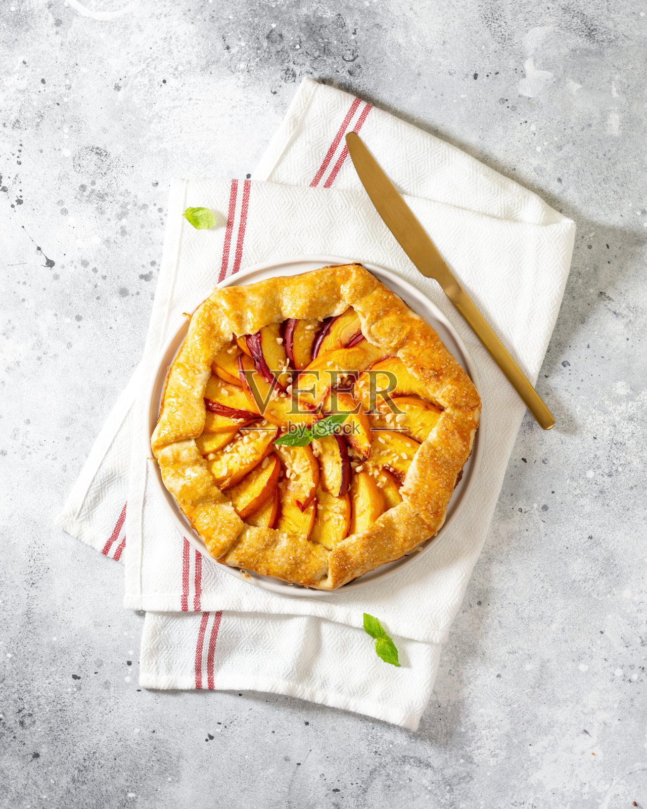 法国馅饼或派与桃子和在一个白色盘子上浅灰色烹饪背景俯视图。夏季自制甜点照片摄影图片