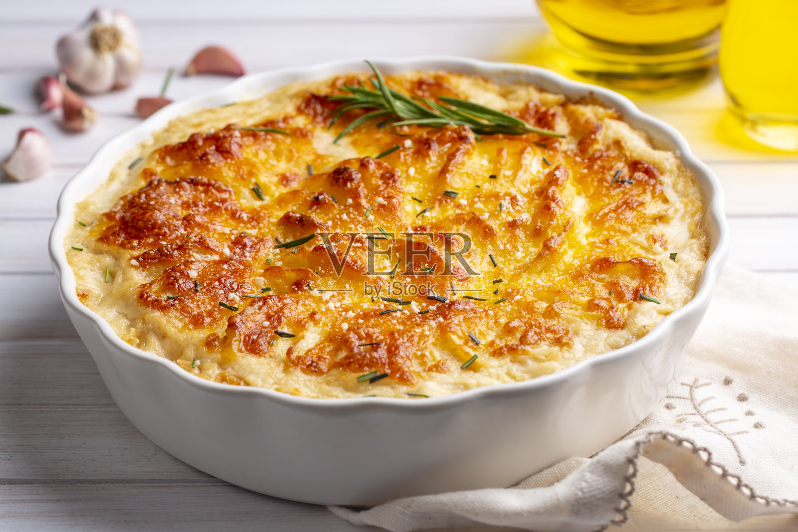 烤土豆——烤土豆配奶油和奶酪，配迷迭香和叉子(土耳其名字;Kremali patates)照片摄影图片