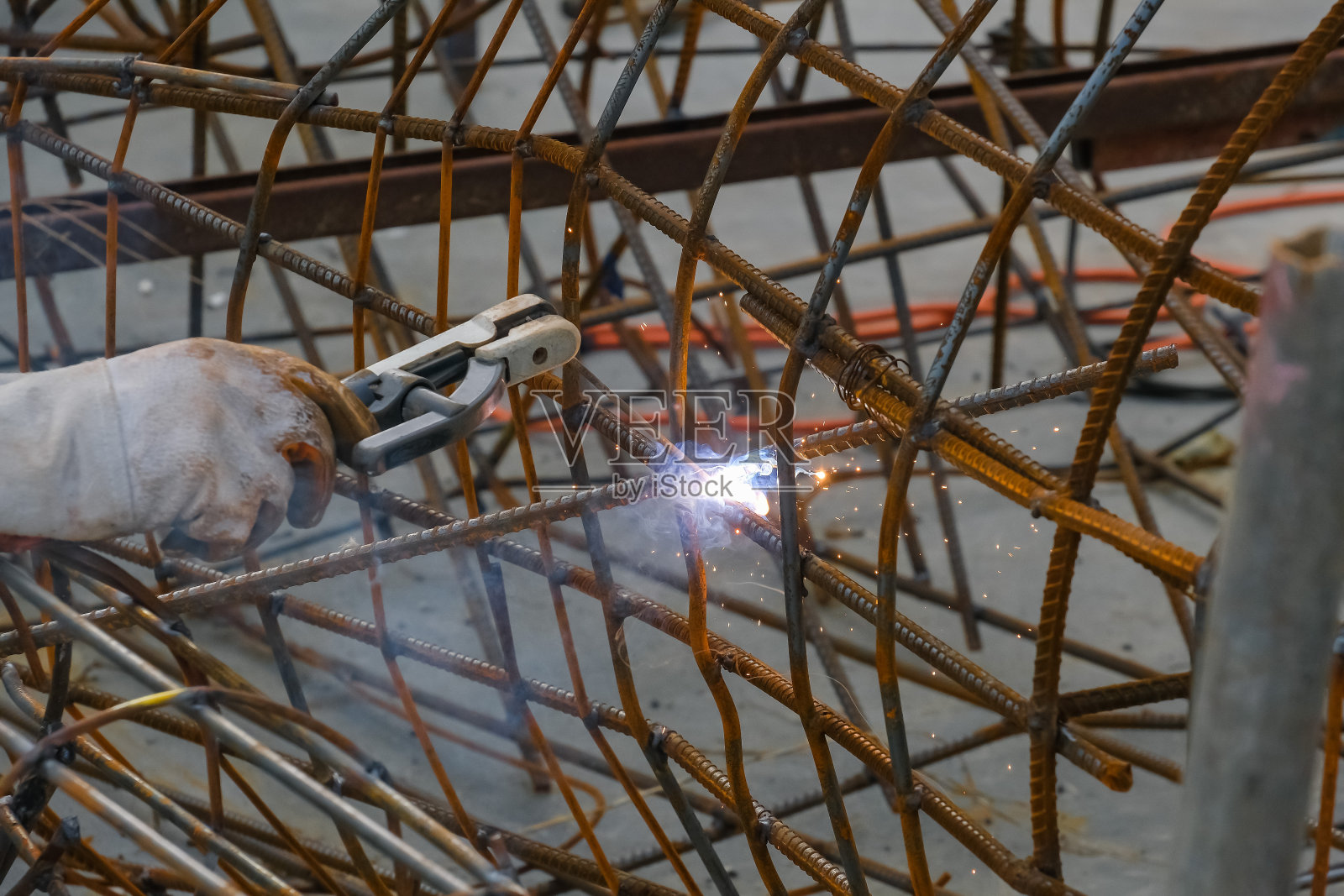 手工焊接钢件，有火花。照片摄影图片