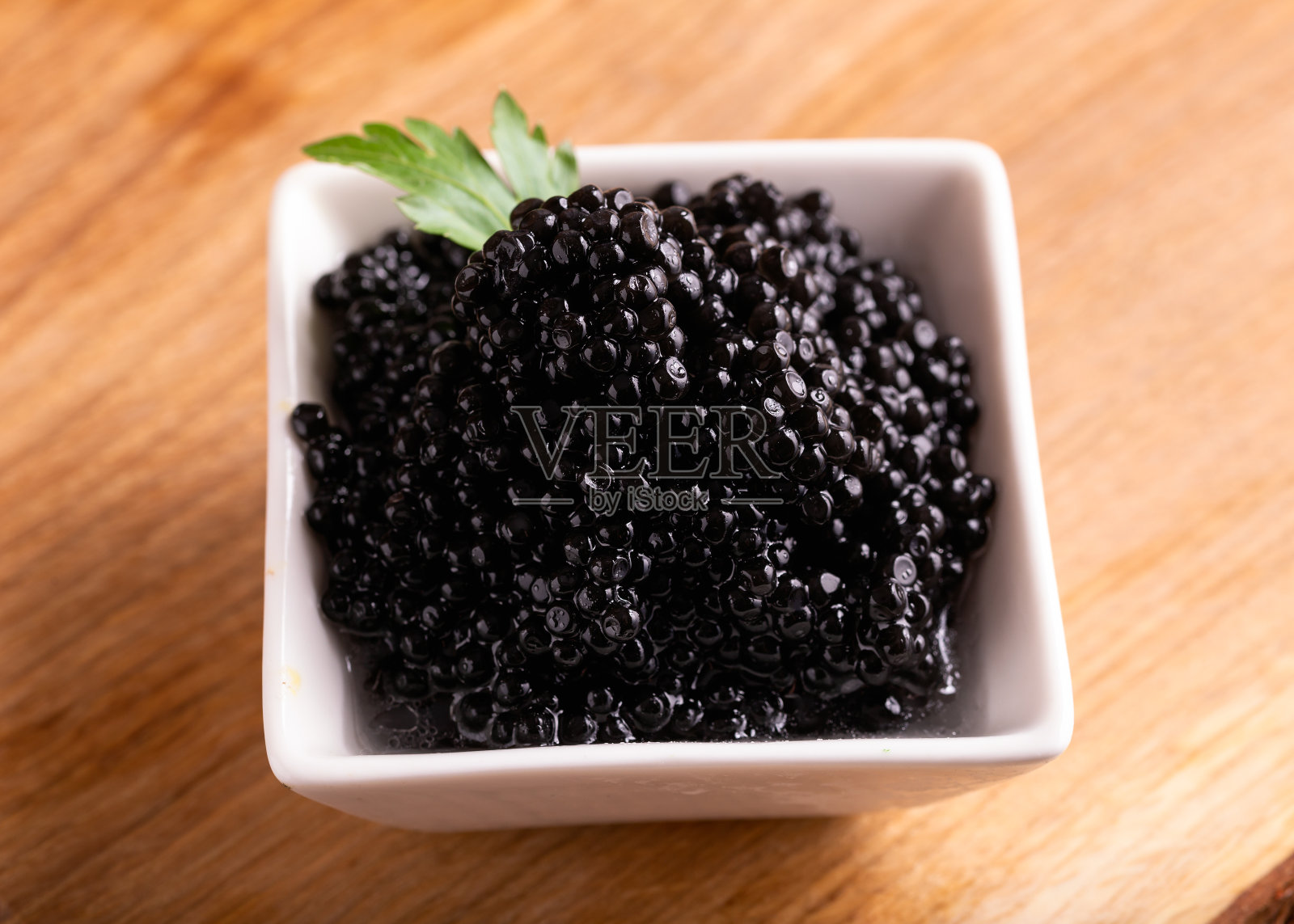 木桌上的黑鱼子酱碗照片摄影图片