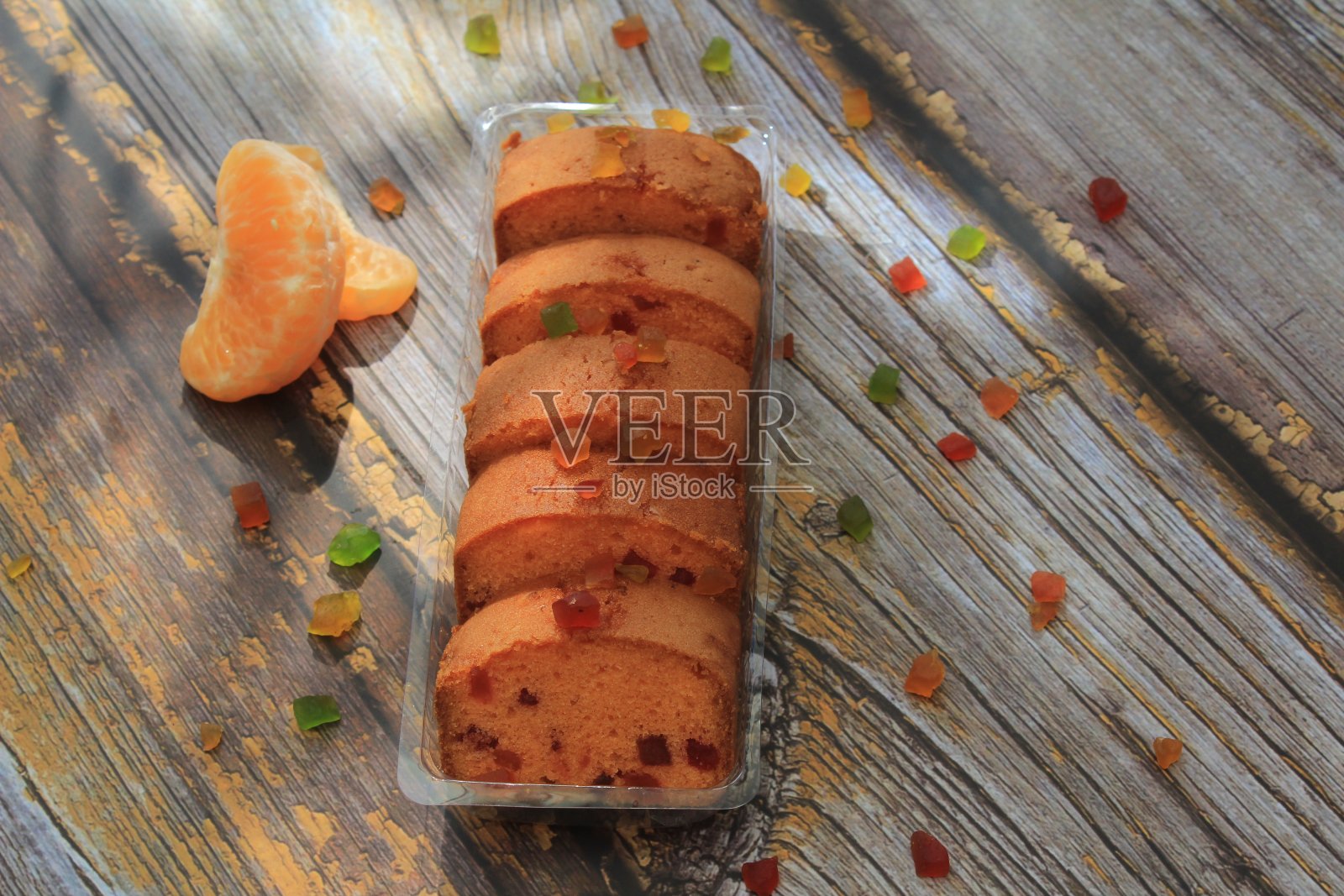 自制的tutti frutti蜜饯水果海绵蛋糕在桌子上和圣诞节的彩色背景照片摄影图片